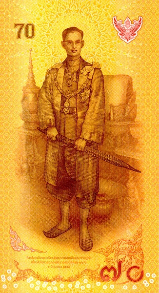  Young King Rama  IX Bhumibol Adulyadej in full regalia holding the Sword of Victory, in front  of the Phuttan Kanchanasinghat Throne inside the Paisan Taksin Hall