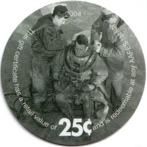 Two soldiers helping  another get into a deep sea diving suit