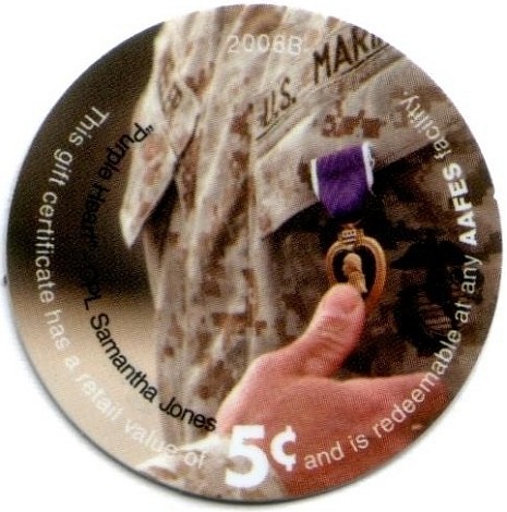 Thumb touching a  "Purple Heart" medal on uniform